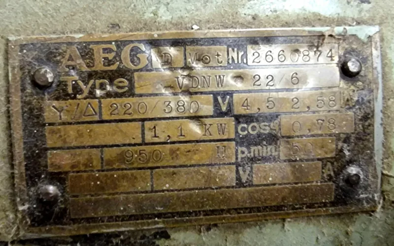 Dirty riveted AEG motor nameplate with stamped numbers
